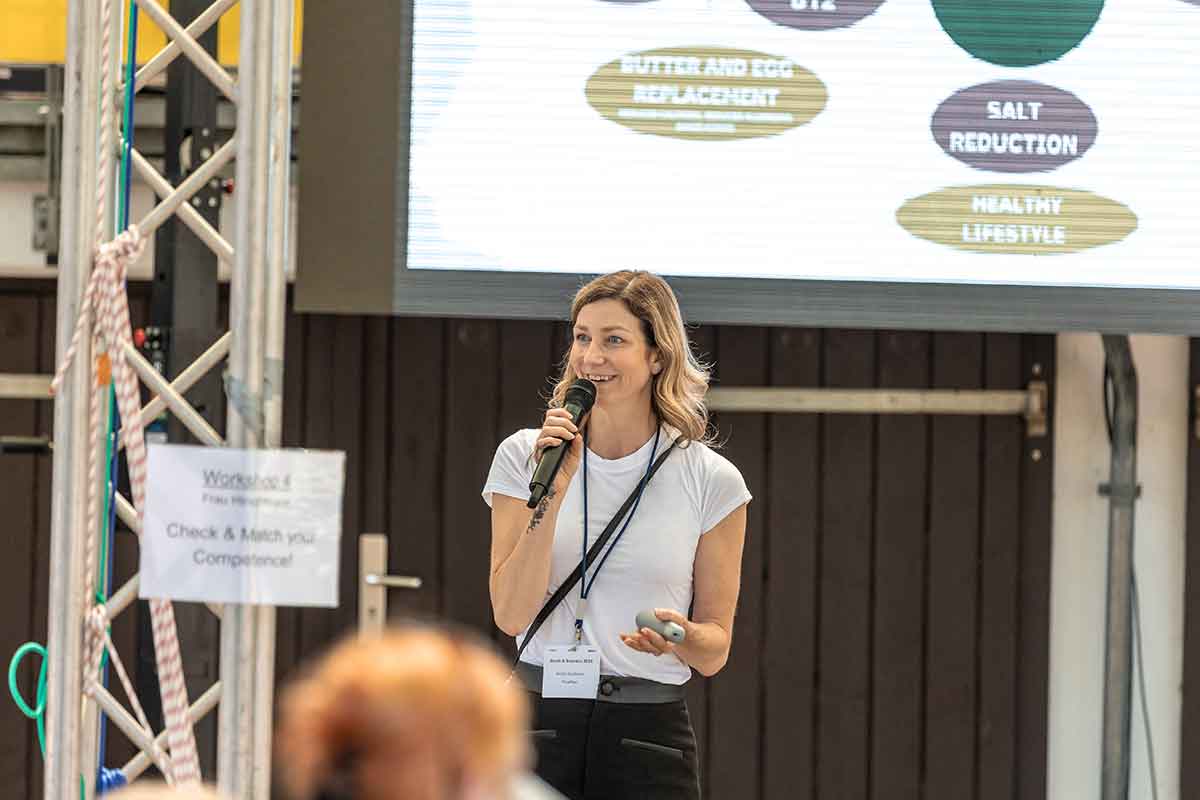 Kirstin Knufmann mit Mikro in der Hand und spricht zum Publikum